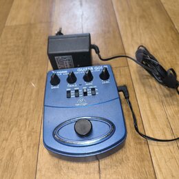Modrá kytarová stupňová pedál s nápisem GUITAR GDI 21 a logem behringer. Zařízení má čtyři ovládací knoflíky s popisky DRIVE, TREBLE, BASS a LEVEL, n…