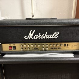 Černý kytarový kombozesilovač značky Marshall, model TSL60 TRIPLE SUPER LEAD JCM 2000 - 60W. Přední panel je zlatý s řadou ovládacích knoflíků, přepí…