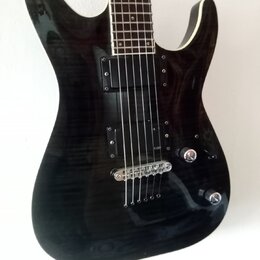 Černá elektrická kytara s výraznou strukturou dřeva na povrchu korpusu. Nástroj má dva humbuckery, jeden ovládací knoflík hlasitosti a jeden tónu. Na…