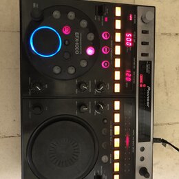 Černý DJ efektový procesor a kontrolér značky Pioneer s označením EFX-1000. Zařízení obsahuje velký ovládací disk s modrým podsvícením, několik menší…
