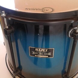 Modrý buben s přechodem do černé barvy. Na koruse je nápis AQUARIAN FOCUS-X. Na korpusu se nachází štítek s textem MAPEX PERCUSSION TECHNOLOGY MARS P…