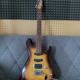 Elektrická kytara s trupem v barevně sunburst a hnedým hmatníkem. Na hlavě je vidět nápis Ibanez. Nástroj má dva humbuckery, jeden jednosmykový sníma…