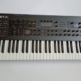 Černý syntetizátor s klaviaturou a ovládacím panelem s mnoha knoflíky, tlačítky a displeji. V levém horním rohu je bílý nápis SEQUENTIAL PROPHET X. P…