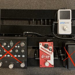 Černý kovový pedalboard s třemi efekty. Vlevo je černý přístroj s nápisy PROFILER a KEMPER, vpravo nahoře bílý pedál s nápisy polytune 3 TRUE BYPASS…