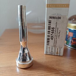 Stříbrný kovový moutník s doprovodnou krabičkou. Na spodní části moutníku je vyryto slovo EXCLUSIVE. Na krabičce jsou nápisy EXCLUSIVE, 9890108 a ští…