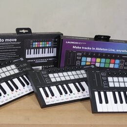 Tři černé MIDI kontroléry s klávesami a barevnými pady, umístěné před dvěma původními krabicemi. Na zařízeních i na obalech je vidět nápis LAUNCHKEY…