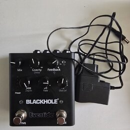 Černý kytarový efekt s nápisy BLACKHOLE a Eventide. Zařízení má šest ovládacích knoflíků s popisky Mix, Gravity Delay, Feedback Q, Size Depth, L.O Ra…