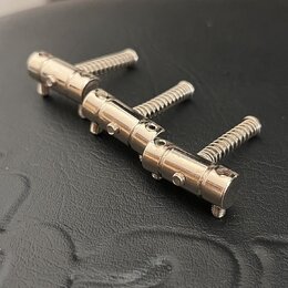 Kovové příslušenství tvořené jednou hlavní lištou a třemi šroubovacími mechanismy. Povrch je nerezový s jemným leskem. Na součástkách nejsou žádné vi…