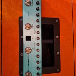 Modře kovový efektový pedál s nápisem M-VAVE v dolní části. Zařízení má čtyři stomečkové spínače označené A/REVERB, B/DELAY, C/MOD a D/AMP, čtyři ovl…
