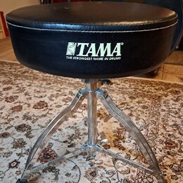 Černý polstrovaný bubeníckýstoliček s chromovaným trojnožným stojanem. Na boku sedáku je bílý nápis TAMA a pod ním text THE STRONGEST NAME IN DRUMS.…