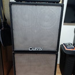 Kytarový stack tvořený černou zesilovací hlavou a dvěma reproduktorovými boxy. Na hlavě je nápis CARVIN RT-120 a RED LINE, na spodní části obou boxů…