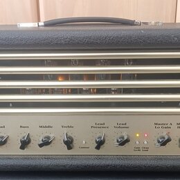 Černý kytarový kombozesilovač s texturovaným povrchem a horní rukojetí. Na předním panelu jsou nápisy Input, Clean, Lead, Bass, Middle, Treble, Lead…