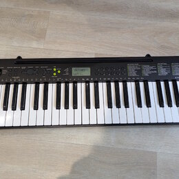 Černý elektronický klavír s bílými a černými klávesami. Na levé straně je nápis CASIO a na pravé straně model CTK-240. Nástroj obsahuje ovládací pane…