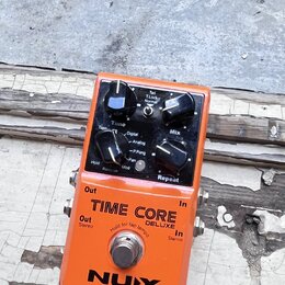 Oranžový kytarový efekt pedál s nápisy TIME CORE DELUXE a NUX. Horní panel obsahuje čtyři ovládací knoflíky s popisky Time, Mix, Reverse Mod a Repeat…