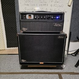Černý kytarový kombozesilovač a samostatný reproduktorové box značky Kustom. Horní jednotka nese nápisy Kustom a DX30 HD, má ovládací knoflíky a přep…