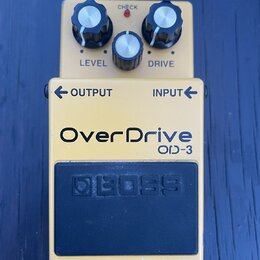 Žlutý efekt pedál s nápisem OverDrive OD-3. V horní části jsou tři ovládací knoflíky s popisky LEVEL a DRIVE a červená kontrolka CHECK. Ve spodní čás…