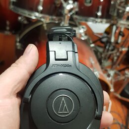Černé uzavřené sluchátka s nápisem ATH-M30x a logem značky Audio-Technica v kruhu. Povrch plastu vykazuje drobné známky používání a lehké znečištění.…