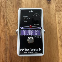 Kytarový efekt pedál v bílém rámu s černým předním panelem. Na panelu je nápis HOLY GRAIL NEO, značka electro-harmonix a text NEW YORK CITY, USA. Obs…