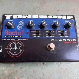 Černý efekt pedál s nápisy TONEBONE, Radial a TUBE DRIVE. Na horní části jsou pět kontrolních knoflíků s popisky LEVEL, HIGH, LOW, FILTER a DRIVE, tř…