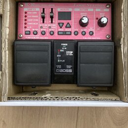 Černý efekt pedál Boss RC-30 Loop Station s červeným předním panelem a dvěma velkými stoupacími spínači. Na panelu jsou nápisy RC-30 DUAL TRACK LOOPE…