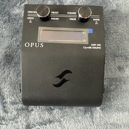 Černý kytarový pedál s nápisy OPUS, AMP SIM a DynIR ENGINE. Horní panel obsahuje dva černé oválné knoflíky a nápisy PERFORM, PRESET, VOLUME, MENU, PA…