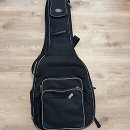 Černý poloměký pouzdro (gig bag) na hudební nástroj s šedým lemováním. V horní části je umístěna kapsa s oválným logem nápisem "Damco". Pouzdro má ně…