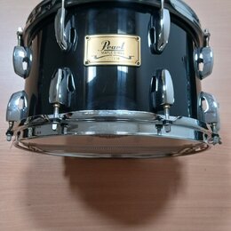 Černý buben s chromovaným obručováním a ladidly. Na korpusu je zlatý štítek s nápisy Pearl, MAPLE SHELL, 000170 a MADE IN JAPAN. Povrch nástroje je g…