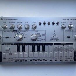 Stříbrný analogový basový syntetizátor s nápisy TD-3 Computer Controlled a Analog Bass Line Synthesizer. Na pravé straně je umístěno logo a značka be…