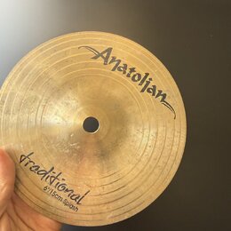 Zlatavý mosazný činel typu splash s viditelným rýhováním. Na povrchu je nápis „Anatolian“ v horní části a v dolní části text „traditional 6"/15cm Spl…
