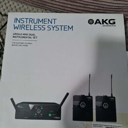 Fotografie znázorňuje krabici s bezdrátovým systémem pro nástroje značky AKG by HARMAN. Na obalu je nápis INSTRUMENT WIRELESS SYSTEM a model WMS40 MI…