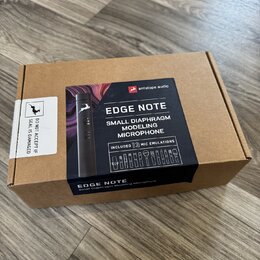 Kartonová krabice s produktem Antelope Audio EDGE NOTE Small Diaphragm Modeling Microphone. Na černé přebalové části je fotografie černého mikrofonu…