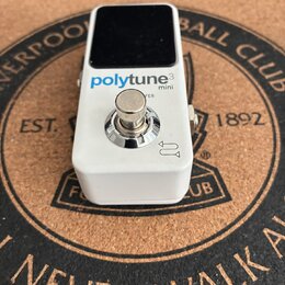 Bílý efekt pedál s černým displejem v horní části. Na přední straně je modrý a šedý nápis polytune3 mini. Uprostřed se nachází kovový spínač a vpravo…