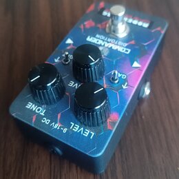 Kytarový efekt s modrým, fialovým a červeným vzorem v podobě šestiúhelníků. Na horní straně je nápis COMMANDER DISTORTION a v pravém horním rohu bílý…