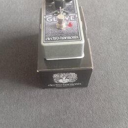 Kytarový efekt v šedém kovovém krytu s nápisem GLOVE a značkou electro-harmonix. Na horní části jsou tři černé ovládací knoflíky s popisky VOL, SHIFT…