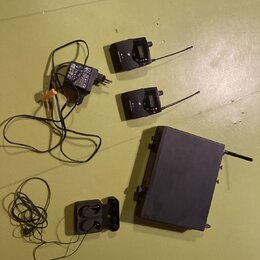 Sada černého bezdrátového systému skládající se z jednoho vysílače, dvou přijímačů a napájecího adaptéru. Na přístrojích je vidět logo s písmenem S a…
