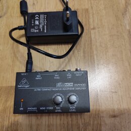 Černý kompaktní sluchátkový zesilovač s nápisem behringer a modelem MicroMON MA400 ULTRA-COMPACT MONITOR HEADPHONE AMPLIFIER. Zařízení má v horní čás…