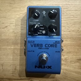 Modrý efekt pedál s nápisy VERB CORE DELUXE a NUX. Na horním panelu jsou dva černé otočné knoflíky s popisky DECAY a LEVEL, přepínač Room/Hall/Plate/…