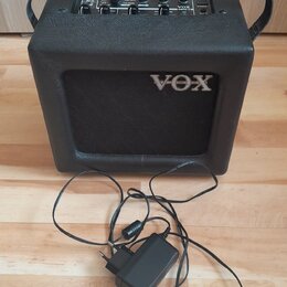 Černý kytarový kombo zesilovač s logem VOX na předním mřížkovém krytu. Horní ovládací panel obsahuje několik potenciometrů a nápisy včetně modelu MIN…