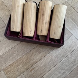 Sada čtyř bambusových koshi chime v tmavě hnědé krabici s purpurovou látkovou výstýlkou. Každá trubice má na spodní části nápis "Koshi". Povrch bambu…