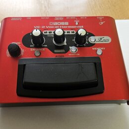 Červený vokální procesor značky BOSS, model VE-2 Vocal Harmonist. Zařízení má několik ovládacích knoflíků a nápisy jako ENHANCE, MEMORY, BYPASS a AUT…