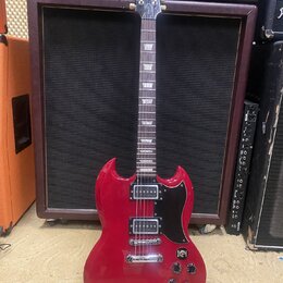 Červená elektrická kytara s černým pickguardem a dvěma humbuckery. Na hlavě hmatníku je nápis Epiphone. Kytara má typický SG tvar těla, čtyři ovládac…