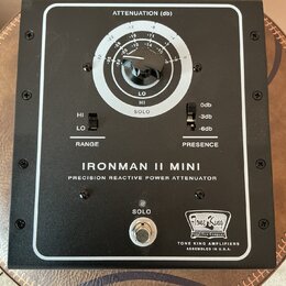 Černý přístroj s bílým rámečkem a nápisem IRONMAN II MINI PRECISION REACTIVE POWER ATTENUATOR. Obsahuje regulační knoflík s označením ATTENUATION (db…
