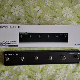 Černý kontrolní pedál s nápisy TC HELICON a SWITCH-6. Zařízení obsahuje šest stomečových spínačů s označením čísel 1 až 6 a doplňkovými nápisy HIT, P…