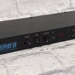 Černý rackový efektový procesor s kovovým šasi. Na předním panelu je nápis ALESIS MIDIVERB II a text 16 BIT DIGITAL EFFECTS PROCESSOR. Zařízení má tř…