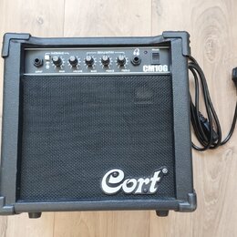 Černý kytarový kombo zesilovač značky Cort, model CM10G. Na horním ovládacím panelu jsou nápisy OVERDRIVE, EQUALISATION, POWER, INPUT, GAIN, VOLUME,…