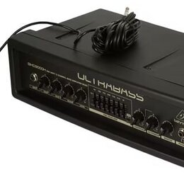 Černý basový zesilovač s nápisy ULTRABASS a Behringer. Na předním panelu je text SKD3000H, řada ovládacích knoflíků a přepínačů. K zařízení je připoj…