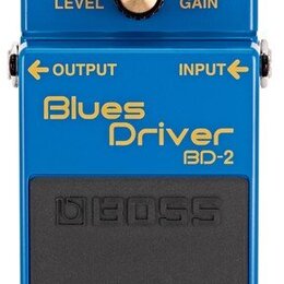 Modrý efekt pedál s nápisy Blues Driver a BD-2. Na horní části jsou tři ovládací knoflíky s popisky LEVEL, TONE a GAIN, červená kontrolka CHECK a zna…