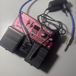 Červený pedál s nápisem RC-30 DUAL TRACK LOOPER a logem BOSS. Zařízení obsahuje řadu tlačítek, posuvníků a malý displej v horní části. K pedálu je př…