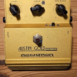 Žlutý kytarový efekt pedál s kovovým tělem. Na přední straně jsou tři černé oválné knofíky s popisky LEVEL, DRIVE a PRE-BASS, přepínač ON a nápisy OU…