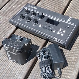 Černý elektronický modul s nápisy YAMAHA, ELECTRONIC ACOUSTIC DRUM MODULE EAD10 a logem EAD. Zařízení obsahuje několik otočných ovladačů, tlačítka ST…